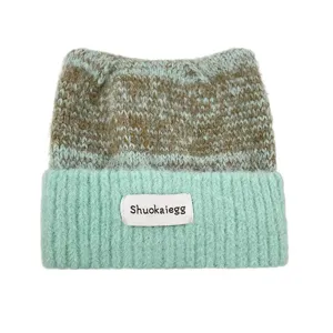 Détail bonnet tricoté oreilles de chat, rayures vert menthe et marron, bonnet chaud.