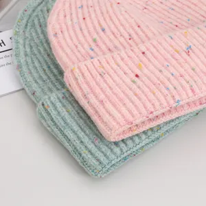 Close-up shot showing the detailed knit texture and colorful flecks of the warm woolen beanie.