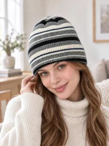 Primo piano dettagliato di un berretto in maglia a righe elegante da donna nero grigio bianco.