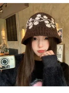 Dettaglio del cappello in maglia jacquard marrone, con trama accogliente e stile caldo.
