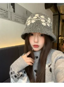 Dettaglio di cappello secchiello in maglia jacquard grigia, con morbida lana e stile invernale.