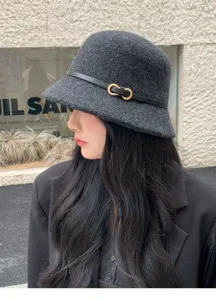Primer plano detallado de un elegante sombrero de cubo de fieltro gris oscuro con hebilla.