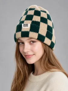 Vista detallada del gorro de punto a cuadros verde y beige usado por la modelo, estilo de invierno.