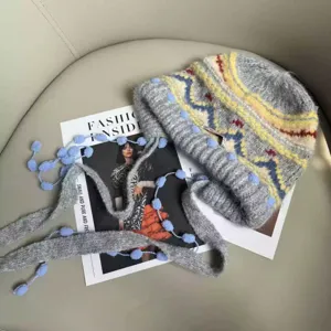 Primo piano berretto lavorato a maglia Fair Isle retro, cappello lana grigio caldo.