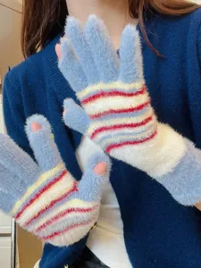 Gros plan de gants en tricot pelucheux sans doigts avec des rayures colorées et douces.