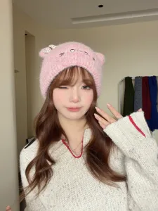 Vista detallada del gorro de punto rosa lindo con orejas de gato y lazo para invierno.