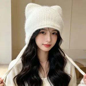 Gros plan d'un bonnet en tricot blanc mignon avec des oreilles de chat et des lanières.