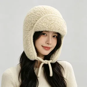 Detailaufnahme einer cremefarbenen Teddyfleece-Trapperhaube mit Ohrenklappen und Bindebändern.