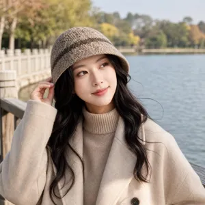 Vue detaillee du chapeau bob en tricot marron texture porte en exterieur pres du lac.