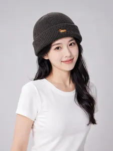 Dark grey knitted beanie detail, cute animal embroidery, warm winter hat closeup view.