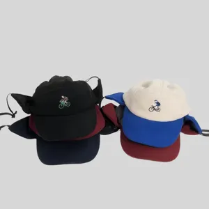 Primo piano sui dettagli del cappello invernale in pile con paraorecchie, design bicolore.