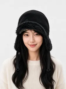 Cappello trapper nero in finta pelle scamosciata con paraorecchie in pelliccia e fodera.