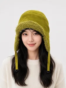 Primo piano del cappello da trappola verde soffice con bordo in pelliccia e lacci regolabili.