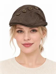 Brown cotton flat cap detail view featuring decorative side buttons and vintage commuter style.