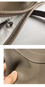 Close-up detail of genuine leather tote bag showing fine pebble grain texture and metal snap.