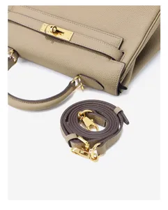 Gedetailleerd overzicht van de hoogwaardige lederen handtas met gouden hardware en riem.