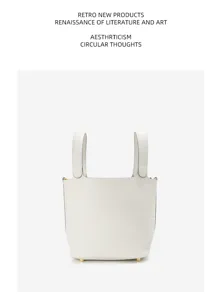 Detailed view of the premium leather bucket handbag in crisp white with gold hardware.