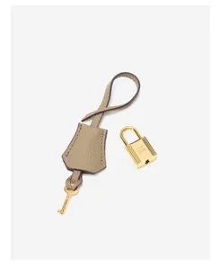 Close-up detail van luxe lederen hangslot en sleutel clochette accessoire set met gouden beslag.