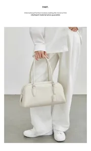 Minimalist leather bowling shoulder bag for women, elegant long handle Boston handbag.