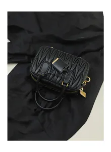 Black quilted leather mini bowling bag detail view, showing delicate matelassé texture.