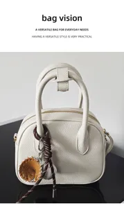 Detailed view of women leather bowling handbag with cute baseball charm, stylish shell bag design.