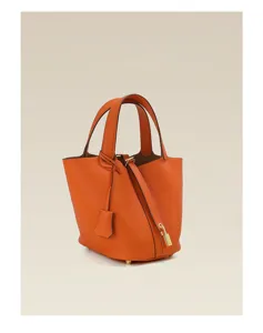 Orange leather bucket handbag detail view, premium pebbled cowhide craftsmanship, classy look.