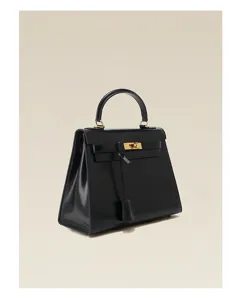 Sac à main noir en cuir véritable vernis avec design trapèze classique et poignée.