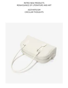 Detail view of the elegant white leather shoulder bag with long straps and sleek design.