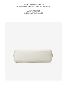 Minimalist leather bowling bag detail in creamy white, premium top layer cowhide craftsmanship.