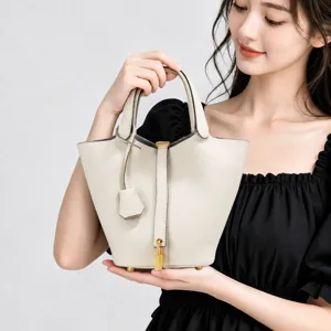 Genuine leather bucket bag with top handle and metal lock design, elegant and spacious main image.