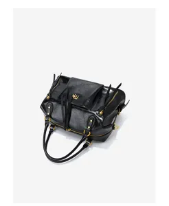 Detail view of black leather motorcycle bag with metal zipper, tassels and shiny hardware.