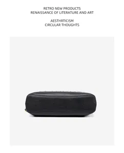 Black leather handbag bottom detail shot, premium cowhide material texture display.
