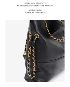 Close-up detail of black genuine leather tote bag with classic quilted pattern and gold chain strap.