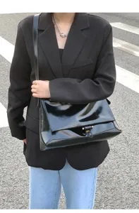 Glossy genuine leather shoulder bag for women, large capacity commuter messenger bag detail view.