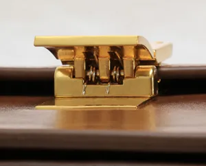 Close-up view of the premium metallic lock clasp on a brown leather handbag accessory.
