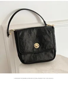 Black genuine leather shoulder bag with chic crumpled texture, gold lock, and stylish strap.
