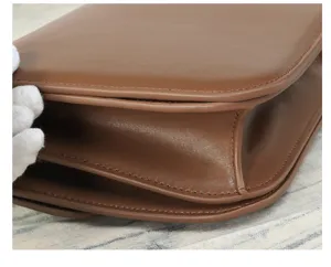 Brown leather crossbody bag detail, high-end texture daily shoulder bag, chic style.