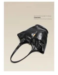 Black leather shoulder bag detail shot, soft slouchy tote with metallic clasp and thin strap.