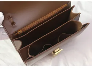 Brown genuine leather structured crossbody bag detail view with interior compartments and lock.