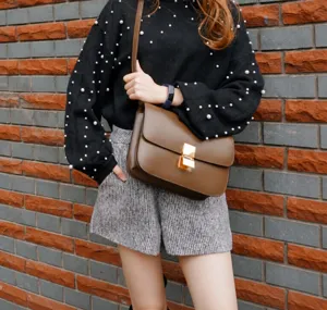 Detailed view of the stylish caramel brown genuine leather crossbody bag with metal lock.