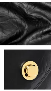 Detailed close-up view of black leather handbag texture and elegant golden hardware turn-lock clasp.