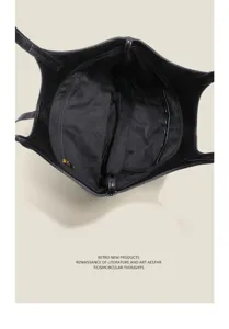 Black leather tote bag interior detail showing large capacity, zipper pocket, and commuting style.