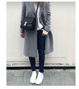 Detailed view of women black leather crossbody bag paired with chic grey wool coat outfit.