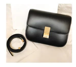 Black leather cross-body shoulder bag detail, elegant square design with metal lock closure.