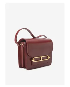 Close-up detail of glossy leather shoulder bag with gold-tone hardware, elegant design.