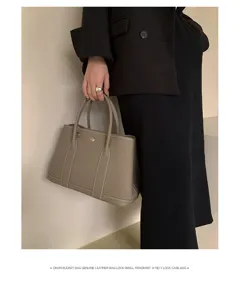 Detailed view of genuine leather tote bag with classic clasp design and comfortable handle.