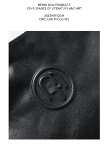 Close-up detail of black genuine leather shoulder bag surface with embossed circular logo texture.
