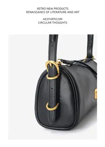 Black leather cylindrical shoulder bag for women, retro barrel pillow bag with gold hardware.