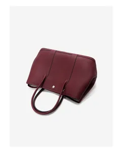 Burgundy leather tote bag detail showing the premium texture, dual handles and snap closure.