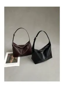 Detailed view of minimalist leather hobo shoulder bags in brown and black on grey surface.